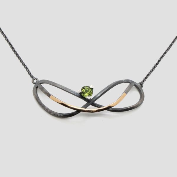 Collar peridoto infinito de plata y oro. Joya creada y hecha a mano por Comin Joieria Creativa